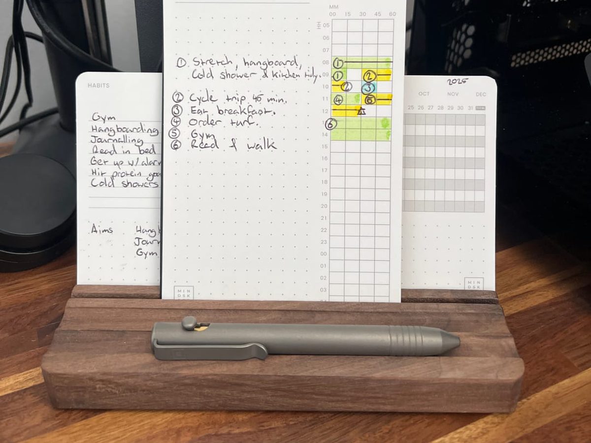 A finished day card standing in the walnut tray with a pen